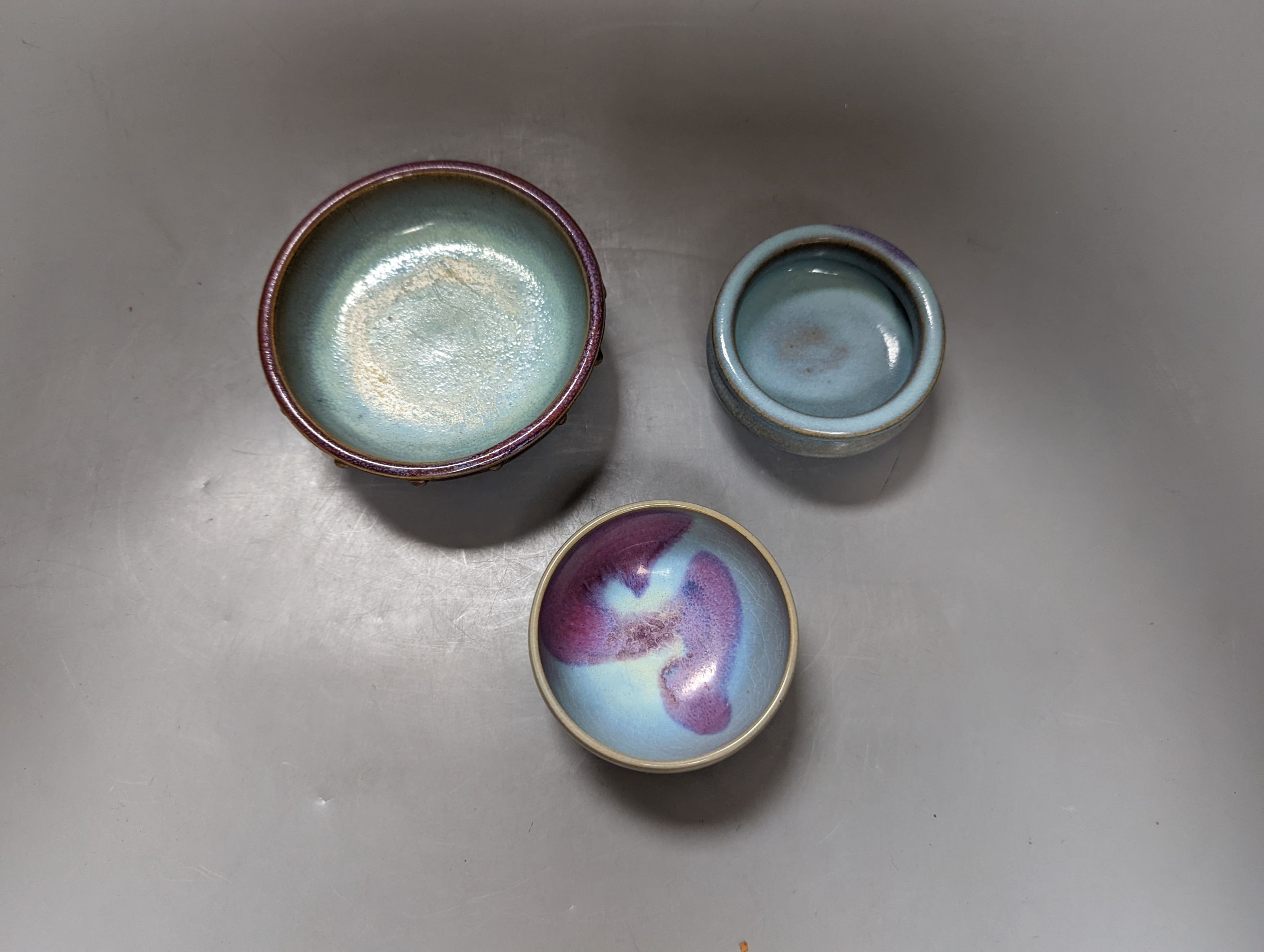 Two Chinese Jun type tripod censers and a similar cup, largest 12 cm diameter (3)
